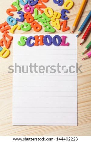 Pencils, colorful numbers and letters with blank paper background on wooden table