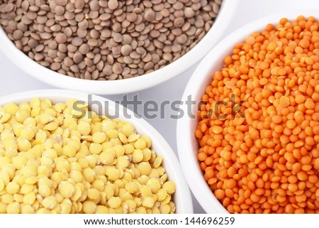Three kinds of lentil in bowls - red lentil, yellow lentil and brown lentil
