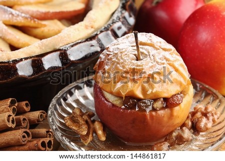 Baked stuffed apple on plate and detail of cake tin with apple pie.
