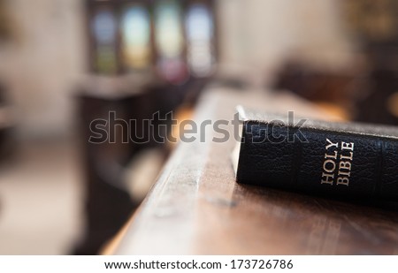 Holy Bible on a wooden church bench.