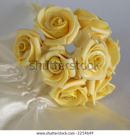 Close-up of bridal gloves and yellow wedding decorations - little roses