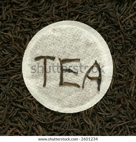 Close-up of black tea leaves and round tea bag