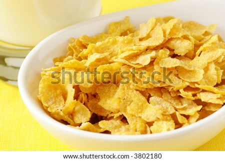 Corn flakes in a bowl and glass with milk