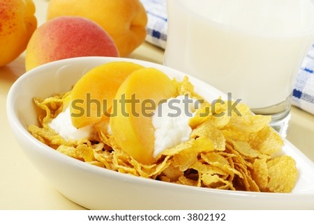 Healthy breakfast - corn flakes with yogurt, fresh apricots and glass of milk