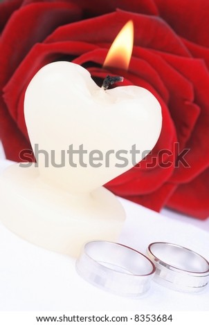 Heart candle, rings and rose - wedding still life