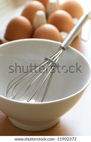 Bowl with whisk with eggs in box, focus on whisk, shallow DOF