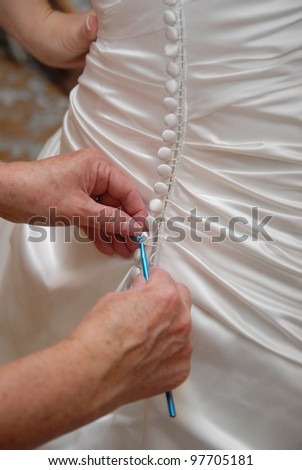 Bride getting dressed in her wedding dress