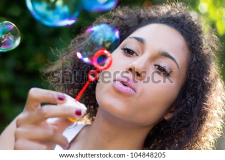 Girl making soap bubbles at park