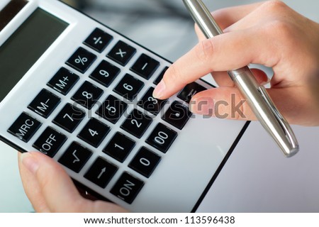 woman's hands with a calculator and a pen