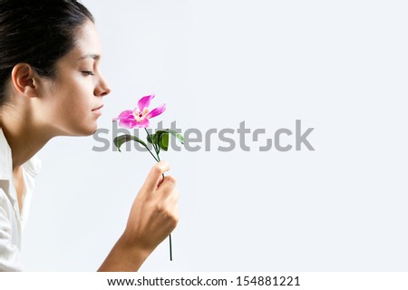 Profile photo of a beautiful girl smelling a flower. Copyspace