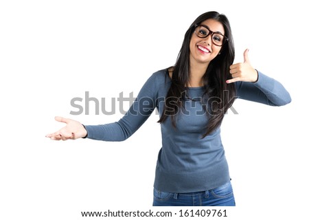 Portrait of a happy young Latin woman making a call me gesture over white background.