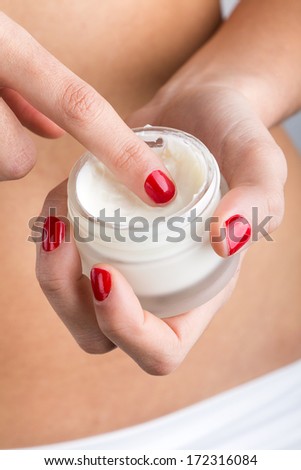 Body care. Close up portrait of Woman applying cream on hands