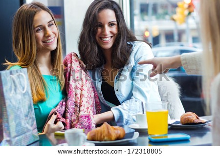 three young friends having breakfast on a morning shopping in the city