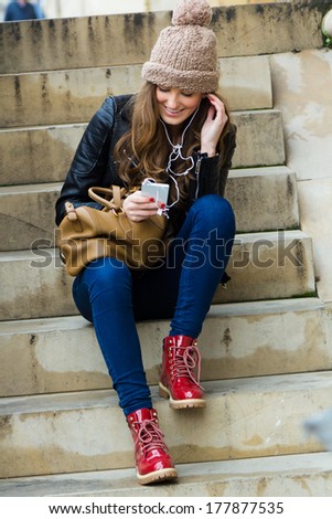 Young woman goes shopping in the city with his mobile phone