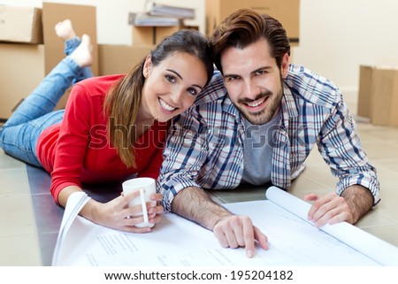 Portrait of Young couple looking at the blueprints of their new home