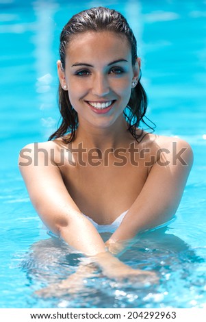 Portrait of beautiful girl posing in the swimming pool.