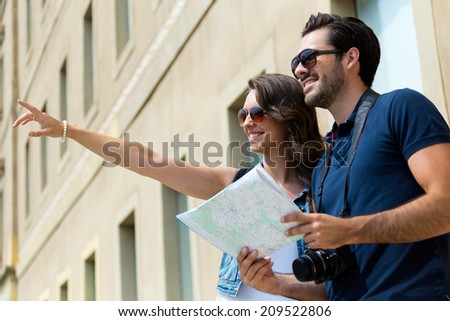 Portrait of young tourist couple use their map and pointing where they want to go.