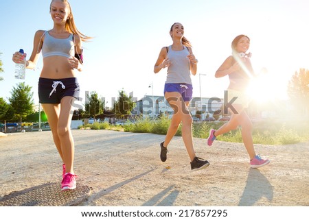 Outdoor portrait of group of women running in the park.