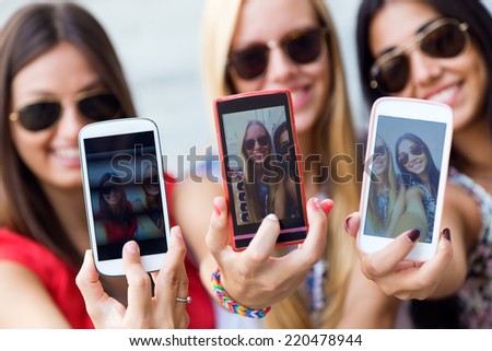 Portrait of three friends taking photos with a smartphone Portrait of three friends taking photos with a smartphone
