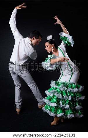 Portrait of young flamenco dancers in beautiful dress on black background.