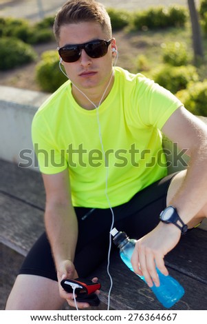 Portrait of handsome young man listening to music after running.