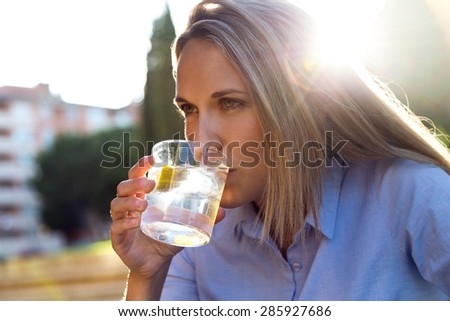 Portrait of beautiful young woman drinking soda in a restaurant terrace.