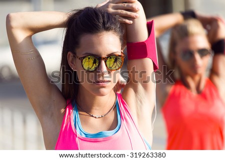 Outdoor portrait of running people doing stretching in the park.