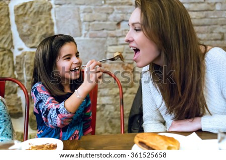Portrait of happy young family having breakfast in the cafe.