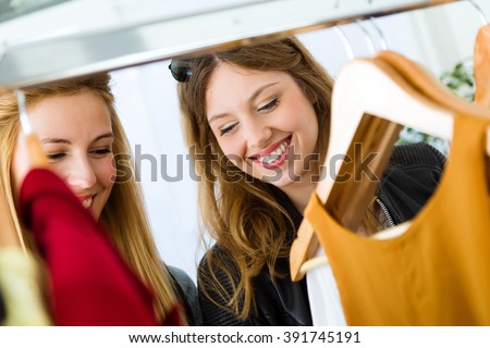 Portrait of two beautiful young women shopping in a clothes shop.
