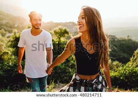 Portrait of beautiful young couple enjoying nature at mountain peak.