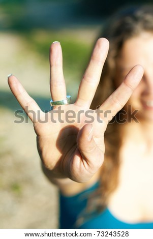 young woman showing the four fingers to the camera