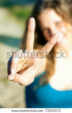 young woman showing the two fingers to the camera
