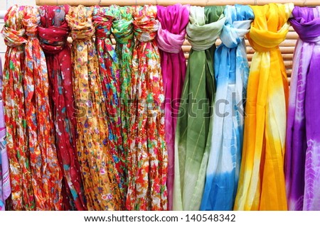 Colorful scarves hanging in a shelf of a fashion shop