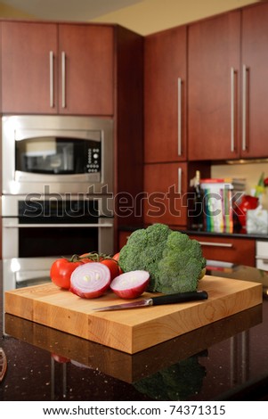 Cutting board with vegetables in a modern cherry kitchen