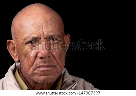 An old man cries whilst staring aimlessly.