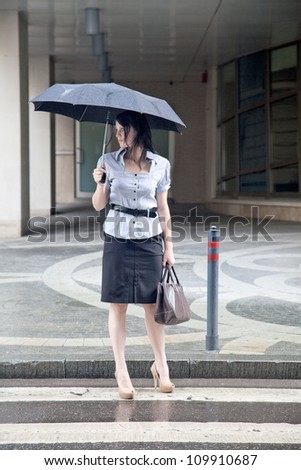 young adult businesswoman on the street under the rain