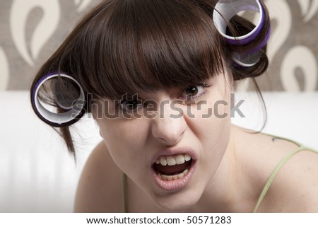 young adult girl with hair rollers angry