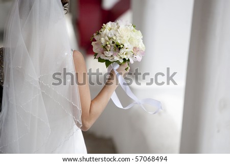 bride back with rose bouquet in hand on wind