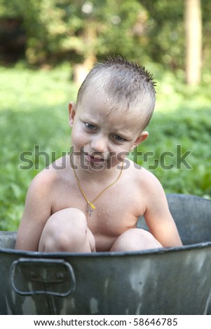 little boy washing in old washing tub outdoor