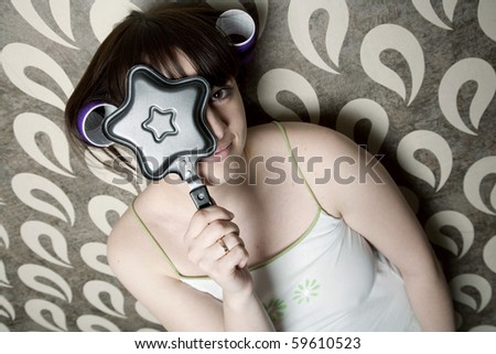 young adult girl with frying pan star and hair rollers have fun