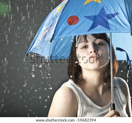 young adult woman under orange umbrella kiss  under the rain