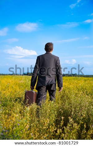 young adult businessman with old two suitcases businessman in the field