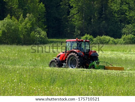 Red tractor on a green field