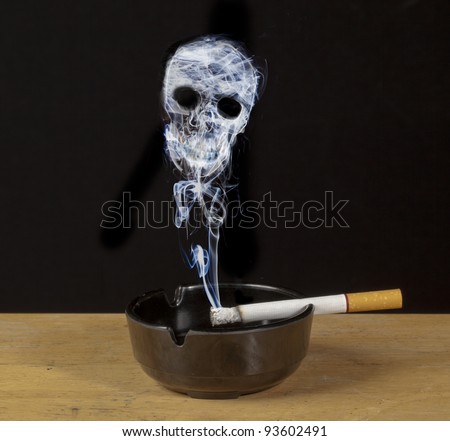 Burning cigarette in an ashtray with a skull formed of smoke , a warning of the hazards of smoking