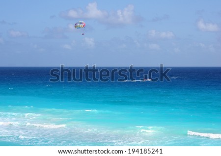 CANCUN, MEXICO - DECEMBER 05: Parasailing in a blue sky over Caribbean sea in Cancun on December 05, 2011. Parasailing is a popular recreational activity among tourists in Cancun, Mexico