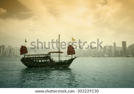 HONG KONG - FEBRUARY 25: The junk boat  in Victoria harbor on February 25, 2013 in Hong Kong. A red chinese traditional junk boat, Aqua Luna, is one of famous tourist attraction