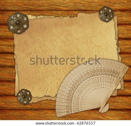 Vintage paper on wooden desk with brooch and fan