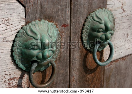 A pair of Chinese door knockers sculpted in the likeness of fierce dragons to ward off evil spirits.