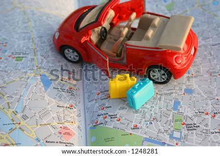 Toy car on luggage on map of Paris.