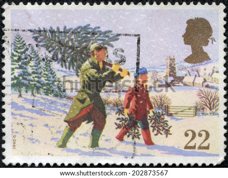 GREAT BRITAIN - CIRCA 1990: a stamp printed in the Great Britain shows Father and child carrying Christmas tree, Christmas, circa 1990